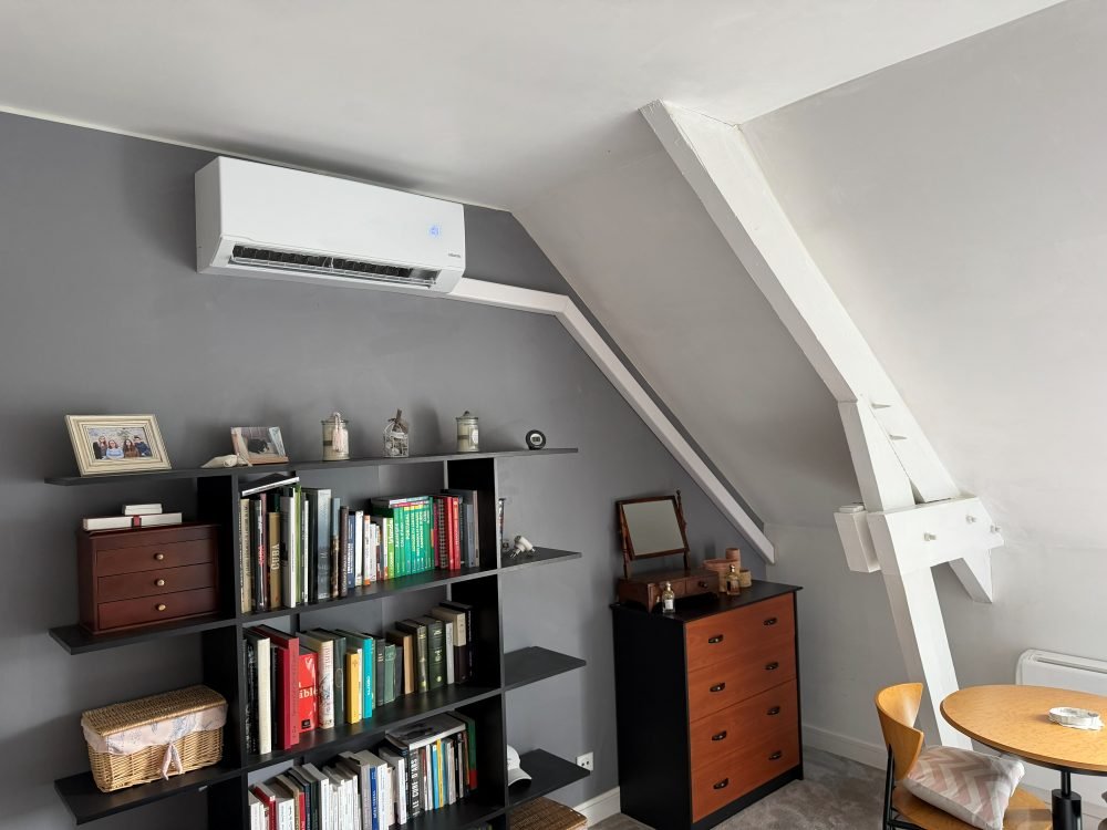 Unité de climatisation murale installée dans une chambre sous combles